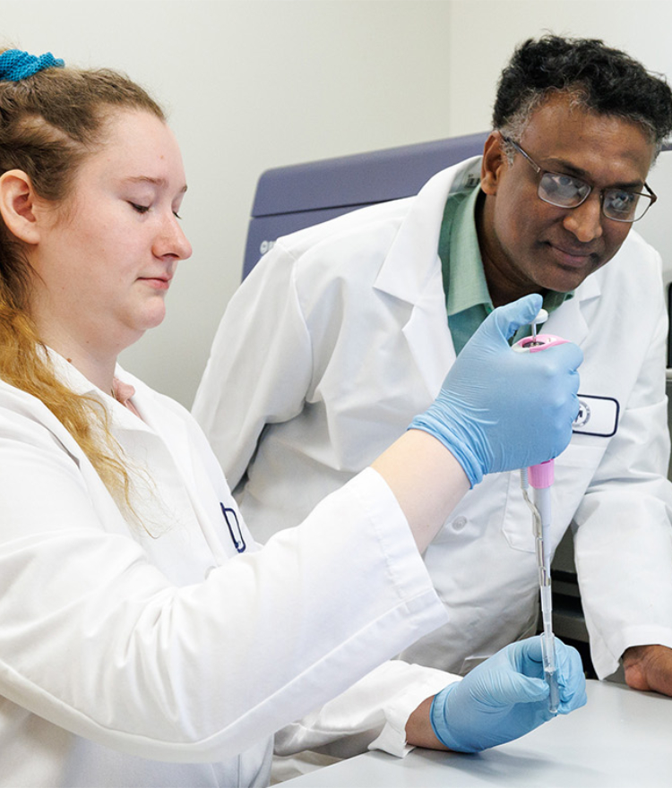 A Mercer professor and graduate student work in a lab.
