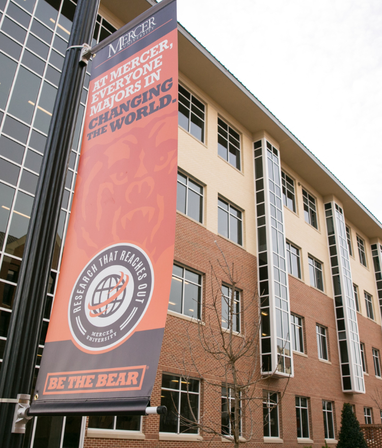 Banner outside the Godsey Science Center reads At Mercer, everyone majors in changing the world.
