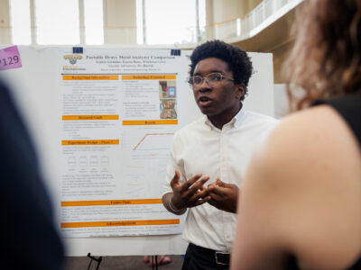 A Mercer student explains his research poster titled Portable Heavy Metal Analyzer Comparison.