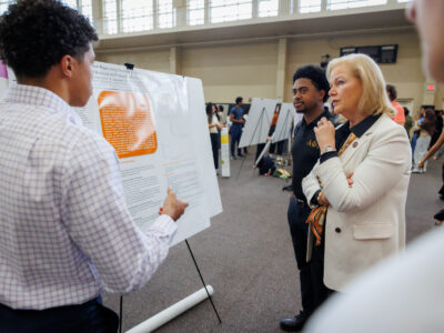 Mercer President Dr. Penny L. Elkins listens as a student explains his research poster.