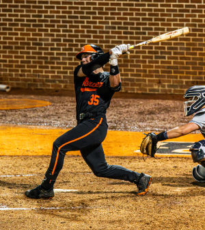 Mercer baseball player #35 in a black and orange uniform follows through on a swing during a game.